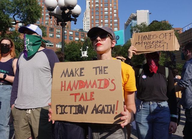 A protester at a pro-abortion rally in Union Square Park holds up a sign reading, "Make the Handmaid's Tale fiction again."